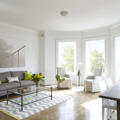 Example of a large trendy open concept medium tone wood floor and brown floor living room design in New York with white walls, no tv and no fireplace