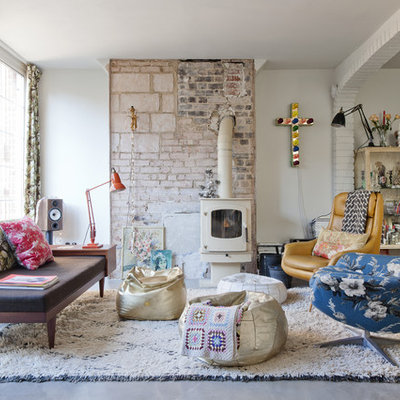 Living room - large eclectic formal and enclosed concrete floor living room idea in Barcelona with white walls, a wood stove and no tv