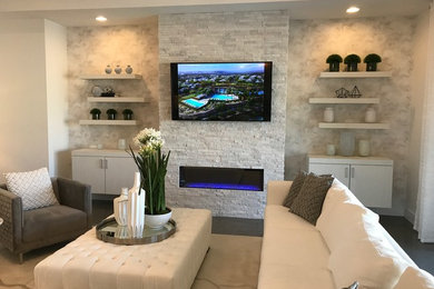 Example of a mid-sized transitional formal and enclosed ceramic tile and gray floor living room design in Las Vegas with white walls, a ribbon fireplace, a stone fireplace and a wall-mounted tv