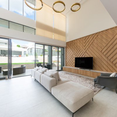 Example of a large trendy gray floor living room design in Sydney with beige walls and a tv stand
