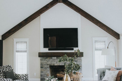 Example of a large transitional open concept dark wood floor and gray floor living room design in Burlington with white walls, a standard fireplace, a stone fireplace and a wall-mounted tv