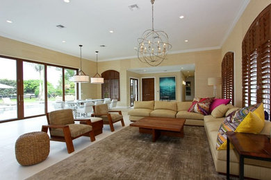 Example of a large trendy open concept limestone floor living room design in Miami with beige walls