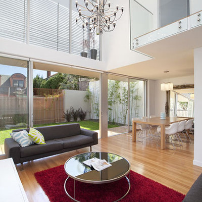 Large trendy open concept light wood floor living room photo in Sydney with white walls