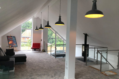 Photo of an expansive contemporary formal mezzanine living room in Hampshire with white walls, carpet, a wood burning stove, a metal fireplace surround, no tv and grey floors.