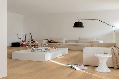 Modelo de biblioteca en casa escandinava de tamaño medio con paredes blancas y suelo de madera clara