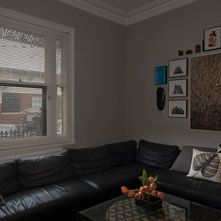 Foto di un soggiorno moderno di medie dimensioni e chiuso con sala formale, pareti grigie, moquette, camino classico, cornice del camino in intonaco, nessuna TV e pavimento verde