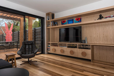 Großes, Abgetrenntes Modernes Wohnzimmer ohne Kamin mit weißer Wandfarbe, braunem Holzboden und freistehendem TV in Melbourne