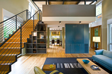 Diseño de salón abierto actual de tamaño medio sin televisor y chimenea con paredes verdes, suelo de madera clara y suelo beige