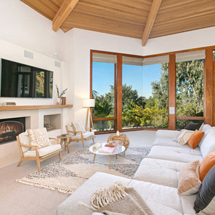 Offenes Modernes Wohnzimmer mit weißer Wandfarbe, Teppichboden, Kamin, Wand-TV, grauem Boden, freigelegten Dachbalken, gewölbter Decke und Holzdecke in San Diego