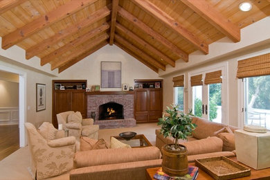 Large transitional enclosed carpeted living room photo in Los Angeles with beige walls, a brick fireplace and a concealed tv