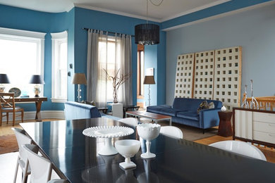 Foto på ett funkis vardagsrum, med blå väggar och ljust trägolv