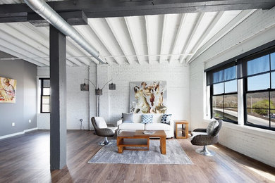 Imagen de salón abierto industrial de tamaño medio sin chimenea con paredes blancas, suelo de madera en tonos medios y suelo marrón
