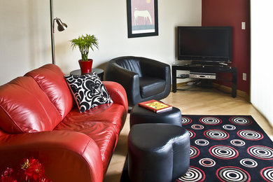 Diseño de salón abierto actual de tamaño medio con paredes multicolor, suelo de madera oscura, televisor independiente y suelo marrón