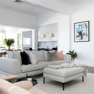 Großes, Offenes Modernes Wohnzimmer mit weißer Wandfarbe, dunklem Holzboden, Kaminumrandung aus Holzdielen, braunem Boden und Holzdielenwänden in Brisbane