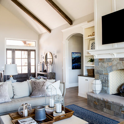 Inspiration for a large cottage open concept medium tone wood floor living room remodel in Salt Lake City with white walls, a standard fireplace, a stone fireplace and a wall-mounted tv