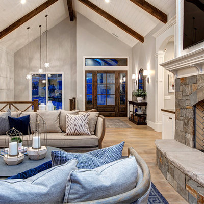 Large cottage open concept medium tone wood floor living room photo in Salt Lake City with white walls, a standard fireplace, a stone fireplace and a wall-mounted tv