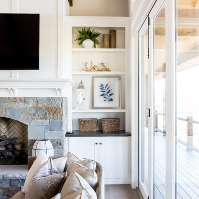 Inspiration for a large country open concept medium tone wood floor living room remodel in Salt Lake City with white walls, a standard fireplace, a stone fireplace and a wall-mounted tv