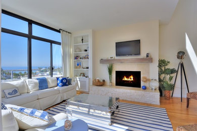 Beach style light wood floor living room photo in Los Angeles with beige walls and a standard fireplace