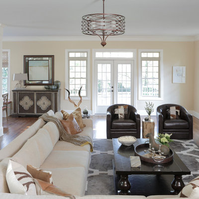 Large country open concept medium tone wood floor living room photo in Atlanta with beige walls, a wall-mounted tv, a standard fireplace and a brick fireplace