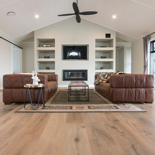 Ispirazione per un soggiorno country di medie dimensioni e aperto con pavimento in legno massello medio, pavimento beige, sala formale, pareti grigie, camino lineare Ribbon e TV a parete