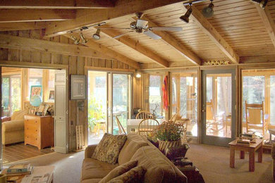 Ejemplo de salón para visitas abierto rural de tamaño medio con paredes marrones, suelo de madera en tonos medios y televisor colgado en la pared