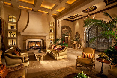 ラスベガスにあるラグジュアリーな広い地中海スタイルのおしゃれなリビング (ベージュの壁、磁器タイルの床、標準型暖炉、テレビなし、石材の暖炉まわり) の写真