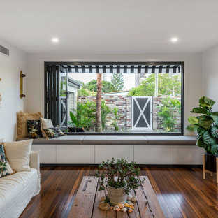 Photo of a beach style formal enclosed living room in Gold Coast - Tweed with white walls, dark hardwood floors and brown floor.