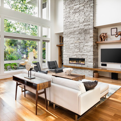 Inspiration for a contemporary medium tone wood floor and brown floor living room remodel in Los Angeles with white walls, a ribbon fireplace, a stone fireplace and a wall-mounted tv