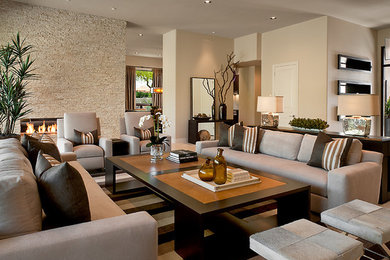 Example of a large trendy open concept carpeted living room design in Miami with beige walls, a standard fireplace, a stone fireplace and no tv