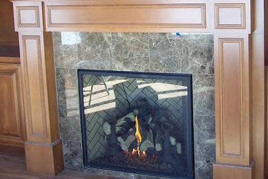 デンバーにあるトラディショナルスタイルのおしゃれなリビング (無垢フローリング、標準型暖炉、石材の暖炉まわり、茶色い床) の写真