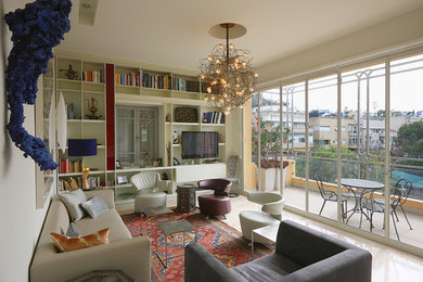 Exemple d'un grand salon moderne ouvert avec une bibliothèque ou un coin lecture, un mur beige, un sol en calcaire, aucune cheminée et un téléviseur encastré.