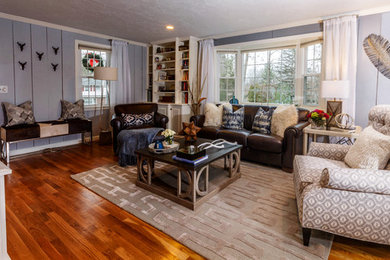 Example of a transitional enclosed medium tone wood floor living room design in Other with gray walls