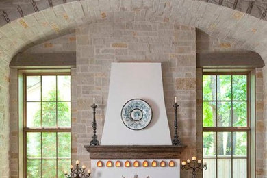 Repräsentatives Mediterranes Wohnzimmer mit braunem Holzboden, Kamin und Steinwänden in Dallas