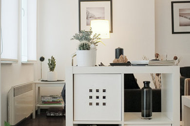 Пример оригинального дизайна: маленькая гостиная комната в современном стиле с белыми стенами, темным паркетным полом и отдельно стоящим телевизором без камина для на участке и в саду