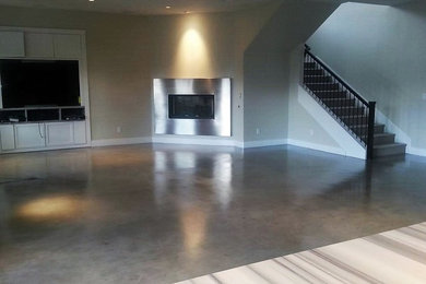 ラスベガスにある高級な広いコンテンポラリースタイルのおしゃれなLDK (グレーの壁、コンクリートの床、標準型暖炉、金属の暖炉まわり、埋込式メディアウォール、グレーの床) の写真