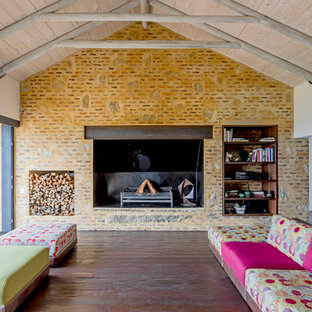 Design ideas for a medium sized eclectic living room in Other with brown walls, dark hardwood flooring, a standard fireplace and brown floors.