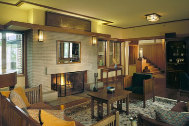 Foto de salón para visitas abierto de estilo americano de tamaño medio sin televisor con paredes amarillas, suelo de madera en tonos medios, todas las chimeneas y marco de chimenea de ladrillo