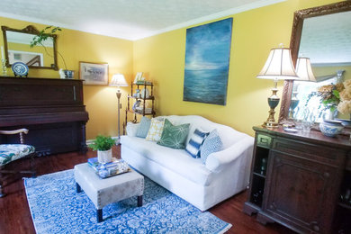 Inspiration for a mid-sized timeless enclosed medium tone wood floor living room remodel in Atlanta with yellow walls