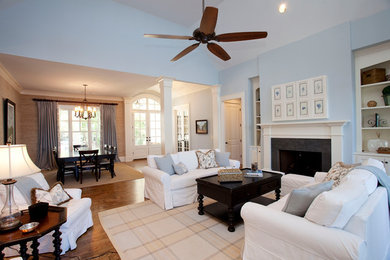 Example of a mid-sized classic formal and open concept medium tone wood floor and brown floor living room design in Atlanta with blue walls, a standard fireplace, a plaster fireplace and no tv