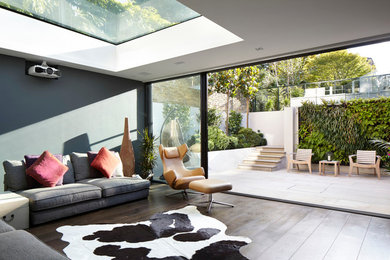 Contemporary open plan living room in London with dark hardwood flooring.
