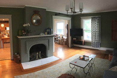 Example of a mid-sized classic light wood floor living room design in New York with green walls, a standard fireplace and a brick fireplace