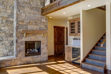 Inspiration for a mid-sized rustic formal and open concept medium tone wood floor living room remodel in Denver with beige walls, a standard fireplace and a stone fireplace