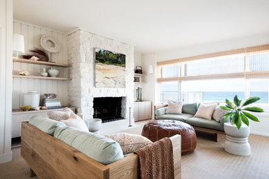 Источник вдохновения для домашнего уюта: парадная, изолированная гостиная комната в морском стиле с белыми стенами, ковровым покрытием, стандартным камином, фасадом камина из камня и бежевым полом