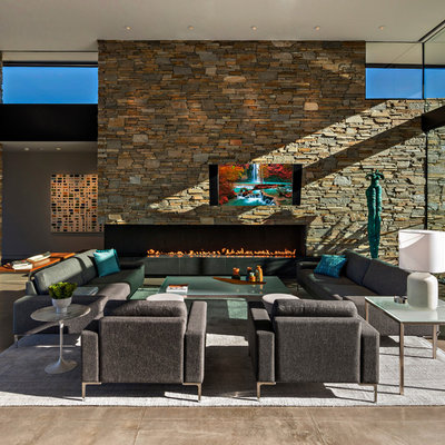 Living room - huge contemporary formal and open concept concrete floor and gray floor living room idea in Phoenix with multicolored walls, a corner fireplace, a stone fireplace and a wall-mounted tv