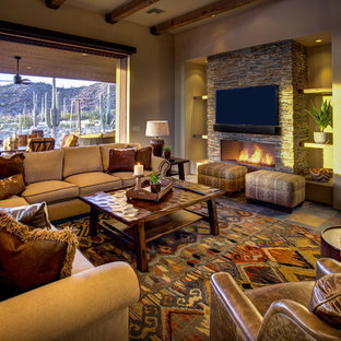Example of a large southwest formal and enclosed slate floor and multicolored floor living room design in Phoenix with beige walls, a standard fireplace, a stone fireplace and a wall-mounted tv
