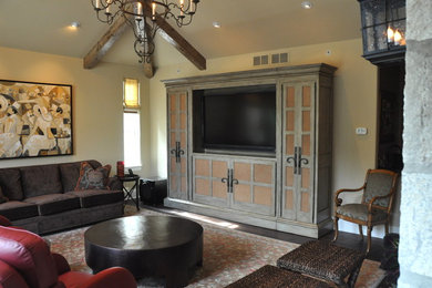 Ejemplo de salón cerrado tradicional de tamaño medio con paredes beige, suelo de madera oscura, pared multimedia y suelo marrón