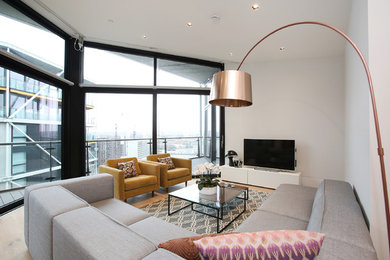 Inspiration for a contemporary living room in London with white walls and light hardwood flooring.