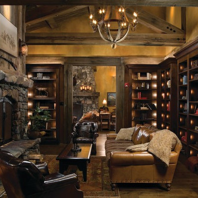 Inspiration for a mid-sized rustic enclosed and formal medium tone wood floor and brown floor living room remodel in Other with a standard fireplace, a stone fireplace, beige walls and no tv