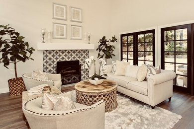 Foto de salón tradicional renovado con suelo de madera en tonos medios, marco de chimenea de baldosas y/o azulejos y suelo beige