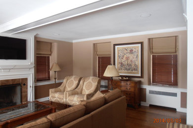 Example of a country enclosed medium tone wood floor living room library design in Philadelphia with a standard fireplace, a tile fireplace and a wall-mounted tv